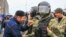 Участник протеста разговаривает с полицейским в Магасе