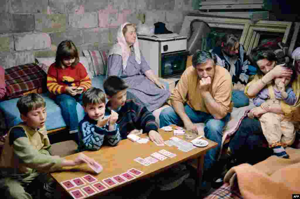 6 июня 1992 года. Семья нашла убежище в подвале, когда Сараево, столица Боснии, оказалась под обстрелами. Бои продолжались, несмотря на достигнутую при посредничестве ООН договоренность об открытии аэропорта и отводе сербских войск из казарм в центре города. 