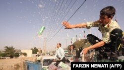Iranian police throw away confiscated beer cans in Tehran in 2009.