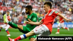 Russian midfielder Aleksandr Golovin (right) and Saudi Arabian defender Muhammad Al-Breik vie for the ball during their opening World Cup match, which Russia won 5-0 on June 14.