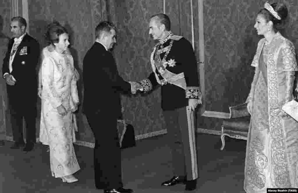 Romanian communist leader Nicolae Ceausescu visits Iran in October 1971. Ceausescu (left) shakes the hand of the shah. Empress Farah is on the right. 