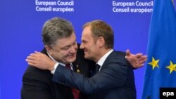 Ukrainian President Petro Poroshenko (left) and EU Council President Donald Tusk hug each at an EU summit in Brussels on February 12.
