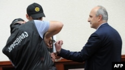 Former Georgian Prime Minister Vano Merabishvili (right) attends a preliminary hearing of his case at the court in Kutaisi, May 22, 2013