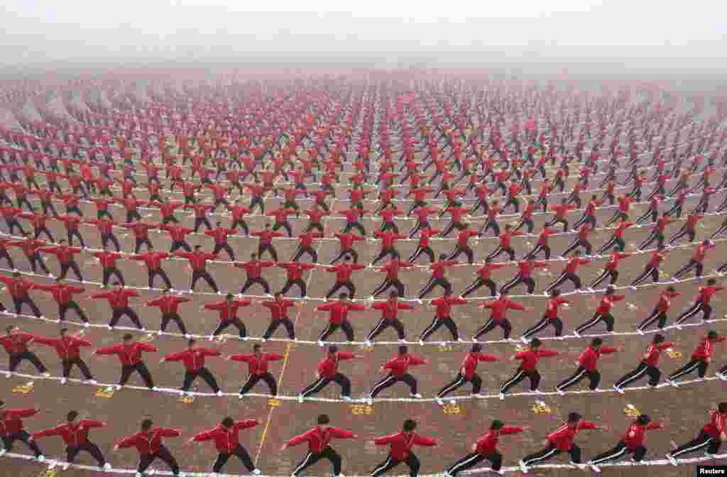  Рагъулал тайпабазул Shaolin Tagou школаялъул футболалъул команда гIуцIиялъул церемониялда китаялъул студентал.  (Reuters/China Daily)