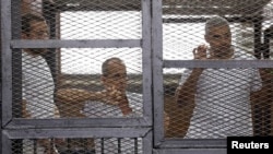 Журналисты "Аль-Джазиры", обвиняемые в пособничестве исламистам, в суде в Каире, 1 июня 2014