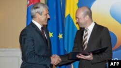 Serbian President Boris Tadic (left) shakes hands with Swedish Prime Minister Fredrik Reinfeldt (right) in Stockholm after he submitted his country's application to join the EU in December 2009.