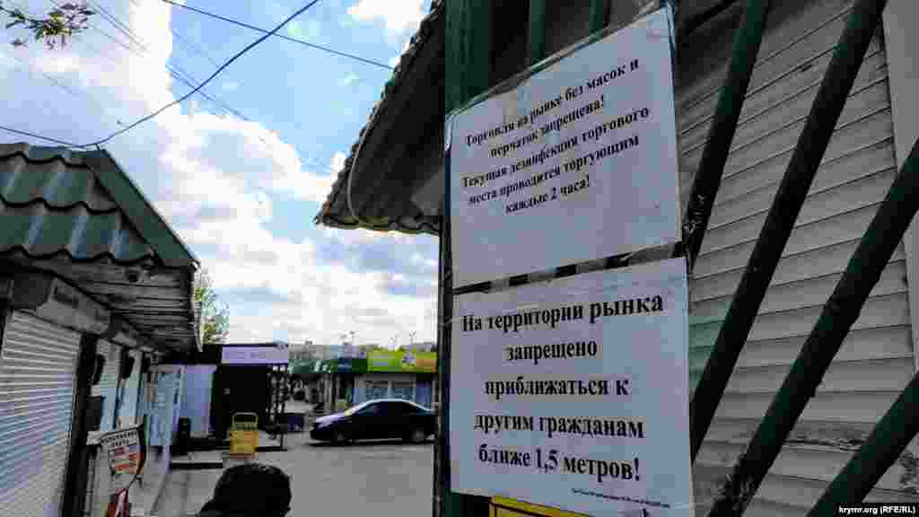 На вході висять оголошення: «Торгівля без масок і рукавичок заборонена», «На території ринку заборонено наближатися до інших громадян ближче 1,5 метра!»