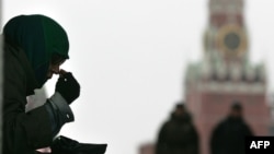 Нищенка, просящая подаяния, крестится на купола Кремля