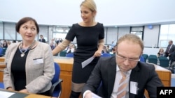 Yulia Tymoshenko's daughter Yevhenia Tymoshenko talks with her mother's lawyers Serhiy Vlasenko (right) and Valentyna Telychenko at the European Court of Human Rights in Strasbourg on August 28.