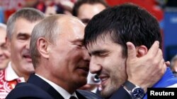 Russian President Vladimir Putin (left) congratulates Russia's Tagir Khaibulayev after he defeated Mongolia's Tuvshinbayar Naidan in their men's 100-kilogram final judo match at the London 2012 Olympic Games.