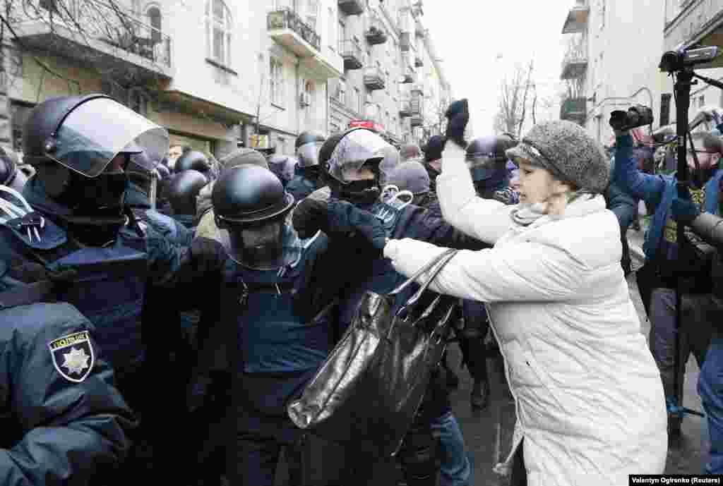 A woman attacks police as they attempt to clear the way for a police van holding Saakashvili. 