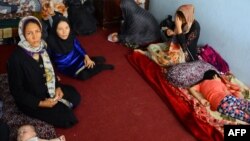 An Afghan family sits in an International Organization for Migration transit center in the western Herat Province after returning from Iran on August 2.
