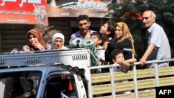 Syrian people leave the Aleppo city center after shelling by Syrian government forces.