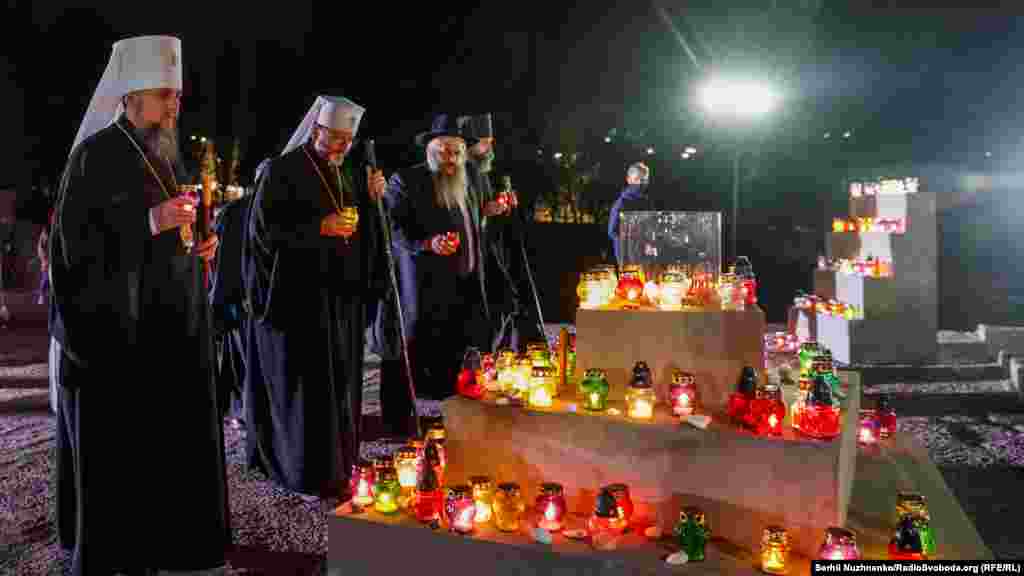 Священнослужителі ставлять лампадки біля пам’ятника киянам і військовополоненим, розстріляним у Бабиному Яру