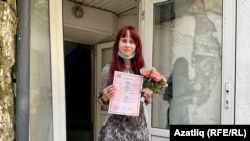 Yelena Gorban shows reporters her wedding certificate on June 23.