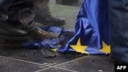 Hungarian protesters trample a burnt EU flag at a rally called by the right-wing party Jobbik in front of the EU headquarters in downtown Budapest in January 2012.