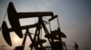 Un muncitor inspectează o pompă de extragere a petrolului din câmpul petrolier PetroChina, din Panjin