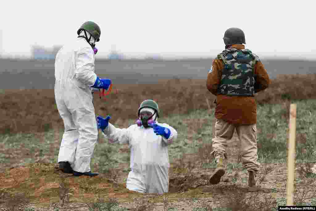 Azerbaijani mine-clearance officers prepare to detonate unexploded munitions. 