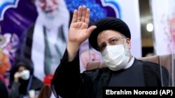 Ebrahim Raisi waves to journalists while registering his candidacy for the upcoming presidential election at the Interior Ministry in Tehran on May 15.