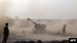 Iraqi Shi'ite fighters from a Popular Mobilization unit use mobile artillery near the city of Fallujah as part of an assault aimed at taking back the city of Fallujah from Islamic State.