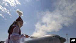 A woman performs a traditional ritual during a ceremony to open a new large aircraft ramp at the Manas Army airbase near Bishkek.