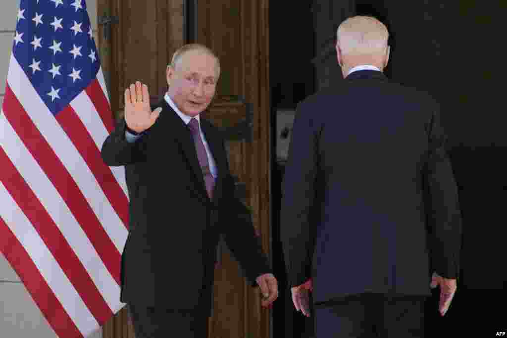 Putin waves before entering the villa with Biden (right). 