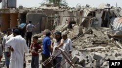 Iraqis stand amid the rubble of destroyed houses following a series of bomb attacks in the country on July 23.