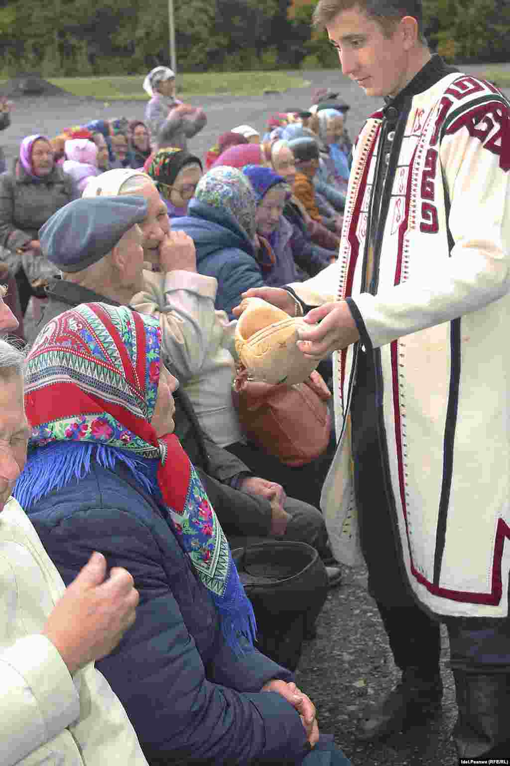 Ковш пива и каравай нового хлеба передаются по рядам. 