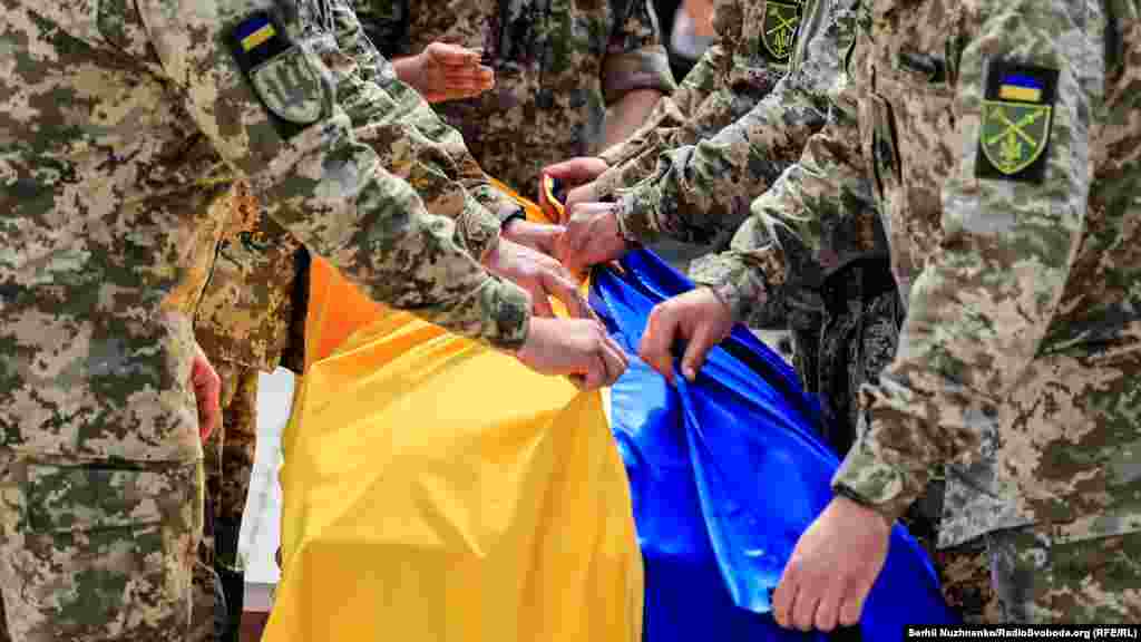 Український прапор на домовині з тілом загиблого військового 