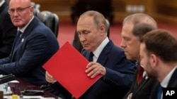 Russian President Vladimir Putin organizes documents at a bilateral meeting with Chinese leader Xi Jinping in Beijing on September 2.