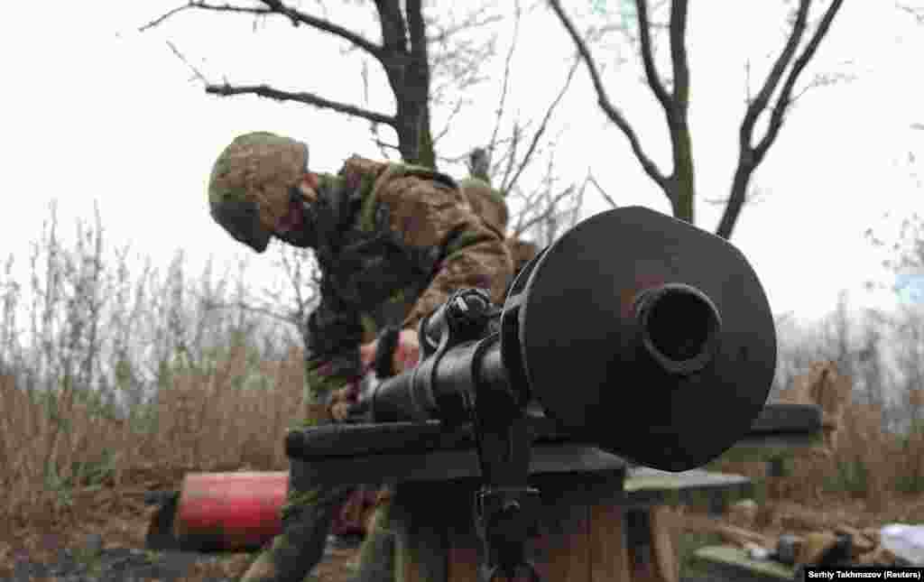 A Ukrainian soldier cleans a weapon. Observers point out that Russia has made large troop movements in the past in connection with regular military exercises. But some analysts say the scale of the Russian military equipment movements is far beyond normal.