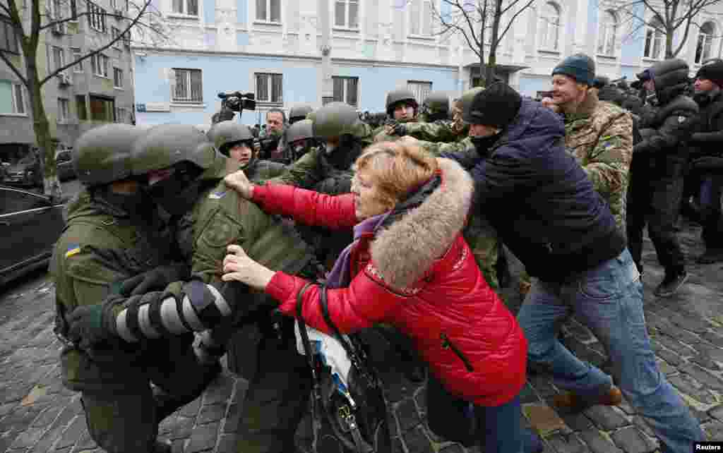 Saakashvili supporters clash with National Guard officers in Kyiv. The numbers of protesters swelled quickly after an associate of Saakashvili published the address of the apartment the police stormed. 