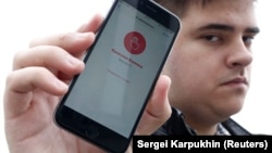 Александр Литреев и телефон с запущенным приложением "Красная кнопка"