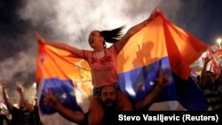 Pro-Serb Monetengrin opposition supporters celebrate parliamentary election results in Podgorica on August 31.