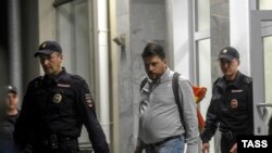 Главу предвыборного штаба ПАРНАСа в Новосибирске Леонида Волкова в сопровождении полицейских выводят из здания избиркома