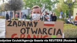 Протестующая на польско-германской границе с плакатом "Требуем открытия границ!"