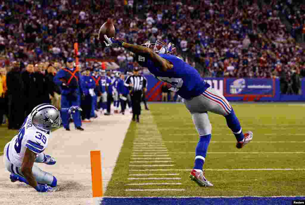 Игрок клуба американской Национальной футбольной лиги New York Giants Оделл Бекхэм зарабатывает тачдаун в матче против Dallas Cowboys. Фотография Эла Белло, первое место в категории "Спорт. Одиночные снимки".  
