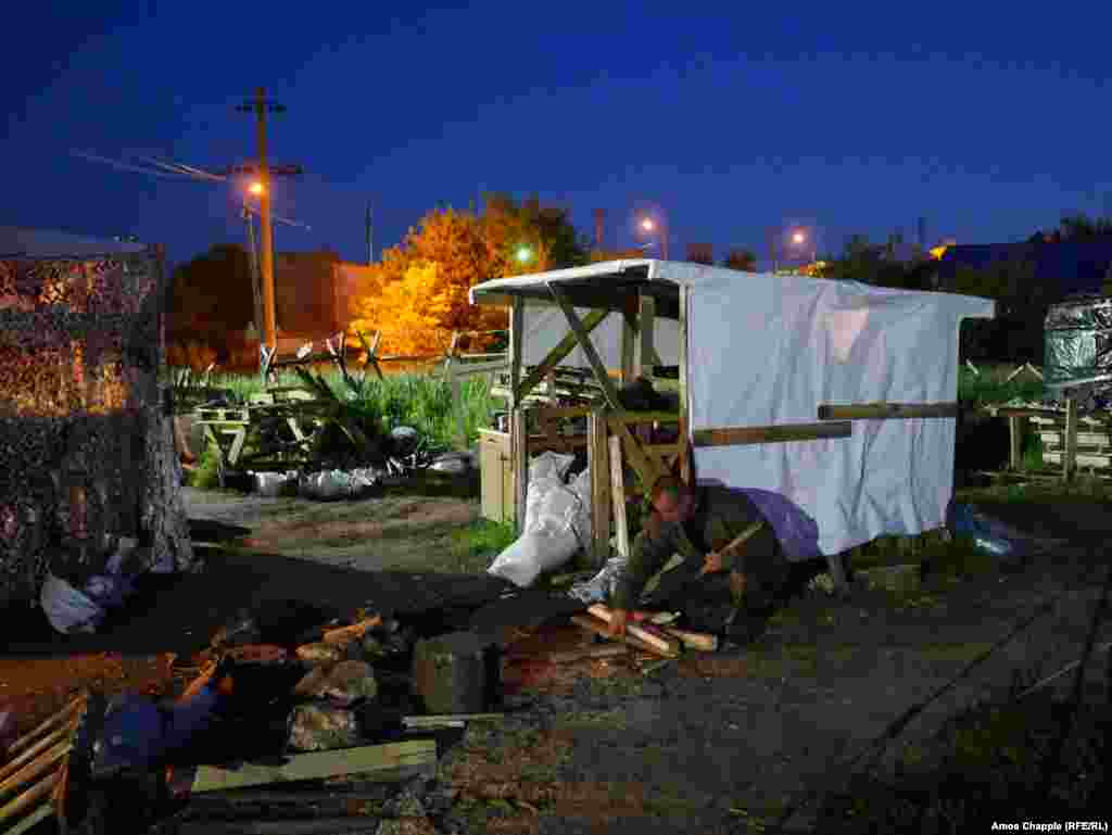 A blockader gathering firewood for the main sleeping tent. The activists declined to reveal details of the coming action, but the leader of the activists told a press conference they would target Russian-owned businesses in "a way no one expects."  