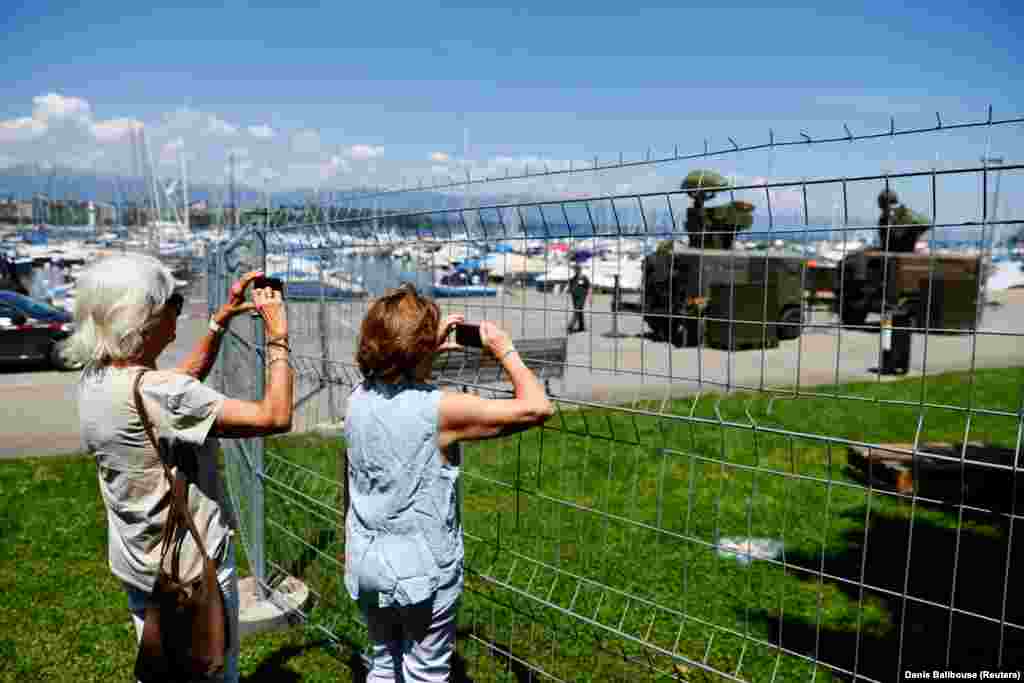 People take photos of a Swiss military radar system set up on the shore of Lake Geneva on June 11. 