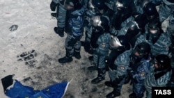 An EU flag lies on the ground near riot police occupying Independence Square.