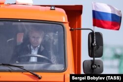 Putin driving the first truck over the Kerch Bridge to Crimea.