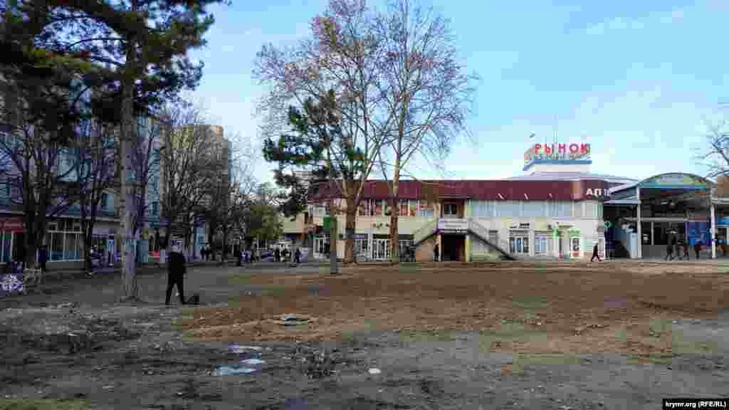 Площадь возле Куйбышевского рынка по-прежнему не приведена в порядок. В августе прошлого года здесь располагался торговый центр «Куб» и различные торговые павильоны. После распоряжения российских властей и многочисленных судебных споров рабочие симферопольского предприятия «Город» приступили к сносу ТЦ, а затем демонтажу объектов. О самом рынке можно почитать здесь