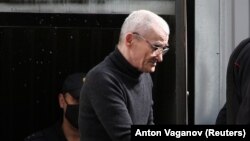 Dmitriyev is escorted by police officers after a court hearing in Petrozavodsk in July 2020. "Harassment is a normal phenomenon," he says. "It means that Memorial is stepping on the authorities' sore places."