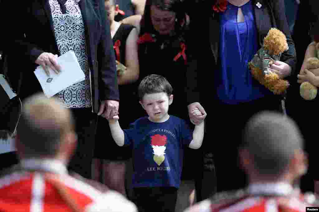 Jack Rigby watches as the coffin of his father, Fusilier Lee Rigby, is carried by members of his regiment after his funeral service at the parish church in Bury, northern England, on July 12. The soldier was murdered in London in broad daylight by Islamist extremists on May 22. 