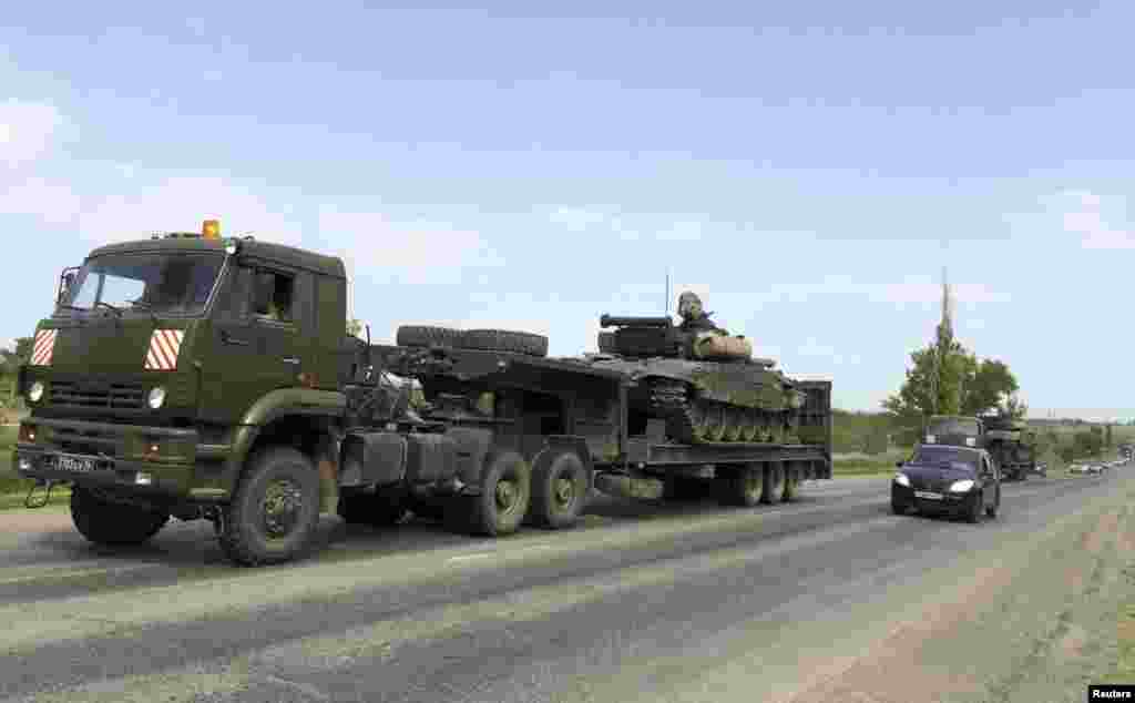 Грузовики перевозят танки по трассе на российско-украинской границе.  За три месяца количество техники на полигоне Кузьминский в Ростовской области увеличилось примерно в три раза