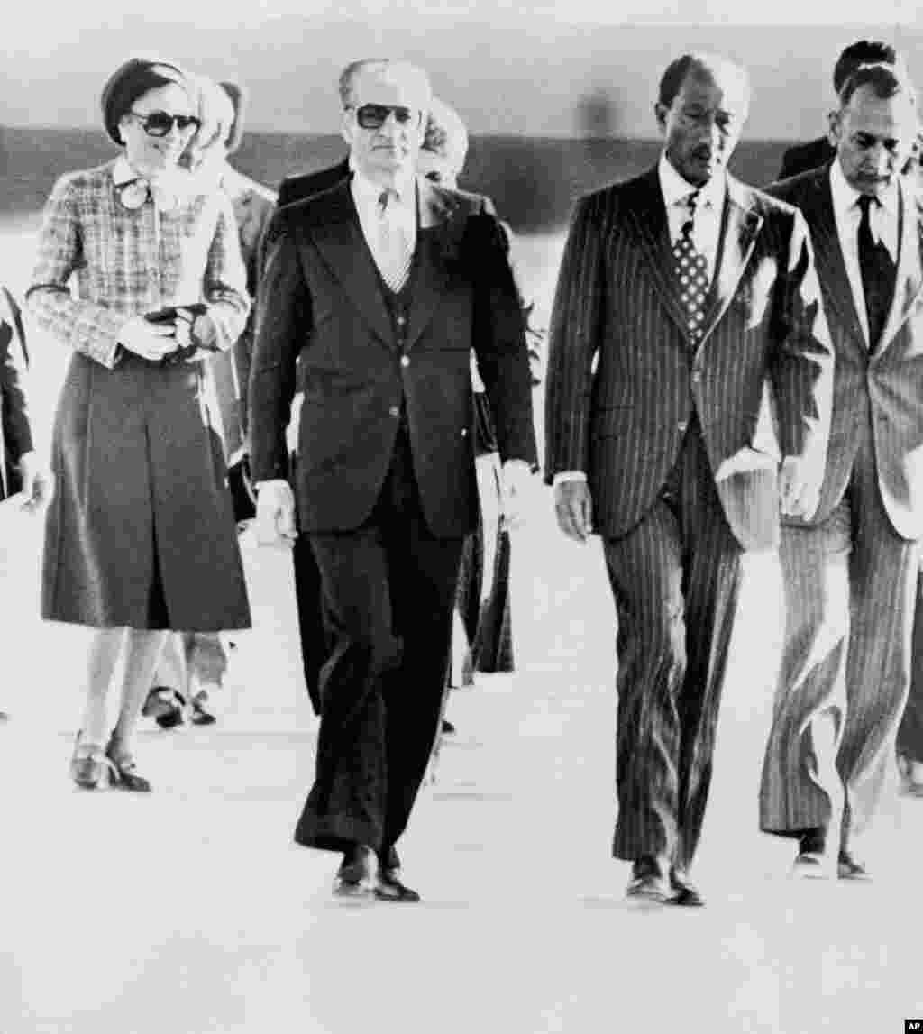 Iran's monarch, Shah Mohammad Reza Pahlavi, leaves his country for the last time on January 16, 1979, going first to Egypt. He and his wife, Empress Farah, were greeted by President Anwar Sadat (second from right). Iranian students were angry that U.S. President Jimmy Carter later allowed the shah to travel to New York for cancer treatment. The shah had fled Tehran amid a surge of demonstrations against his rule. His troops had answered some of them with deadly gunfire.