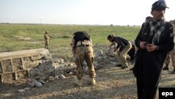 امنیتي سرتېري په جنوبي وزیرستان کې د ځمکلاندې بم چاودنې ځای معاینه کوي - پخوانی انځور.