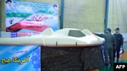 Iranian officials next to what they claim is a U.S. RQ-170 Sentinel drone that was downed in Iran in video broadcast on December 8.