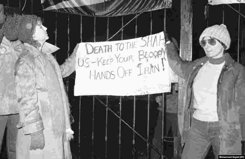 Some U.S. citizens were sympathetic to the Iranian students’ demands: Two Americans, Carol Downer (left) of Los Angeles and Rebecca Chalker (right) of Tallahassee, Florida, hold up a sign in front of the U.S. Embassy calling for the death of the shah on December 15, 1979. The sign was attributed to Chicago postal workers.