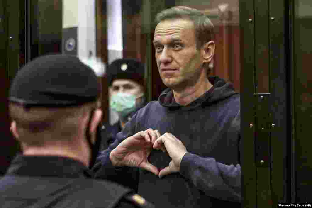 Навальный показывает символ сердца своей жене Юле, стоя в «аквариуме» во время слушания его дела в Московском городском суде